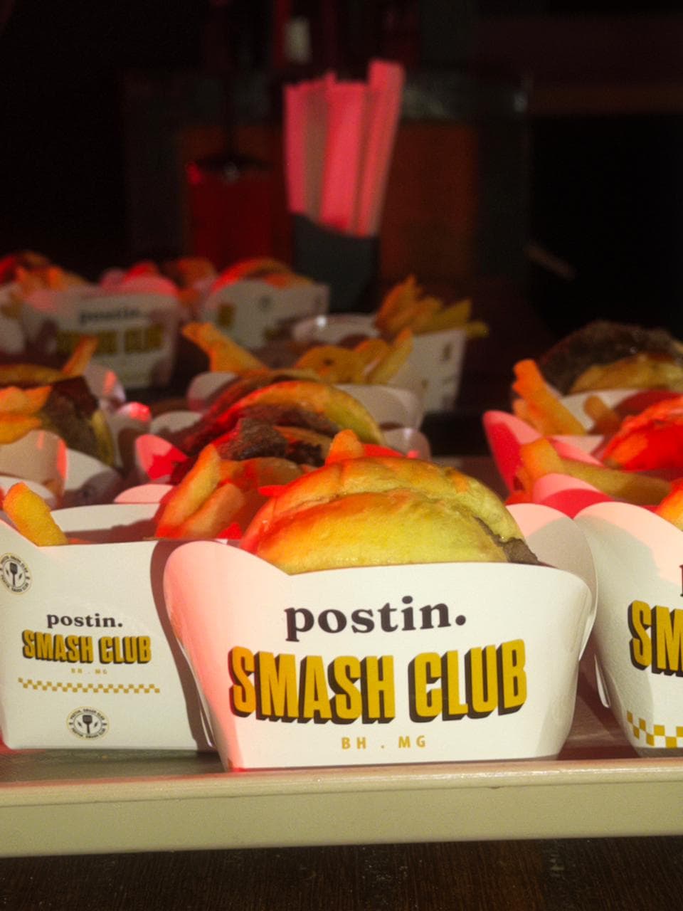 Smash burgers nas embalagens Postin Smash Club, servidos em evento